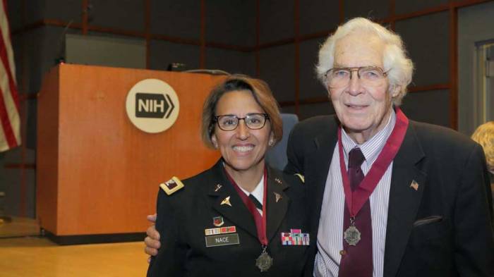 Dr. Lindberg stands with his arm around Colonel Nace. Both are wearing the Ordre of Military Medical Merit medallion.