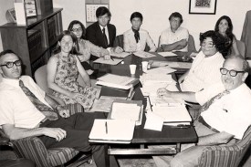 Nine people sitting around a conference table