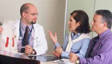 A doctor consults with his patient and her spouse