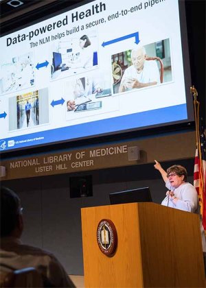 Brennan gestures toward her presentation slide on data-powered health